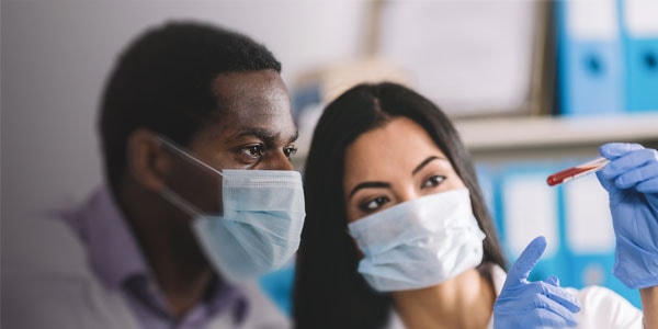 2 healthcare workers reviewing a patient blood sample
