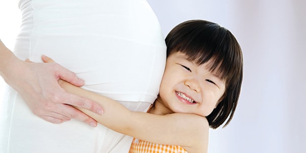 Child hugging pregnant woman