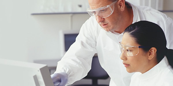 Laboratory man and woman looking at computer screen