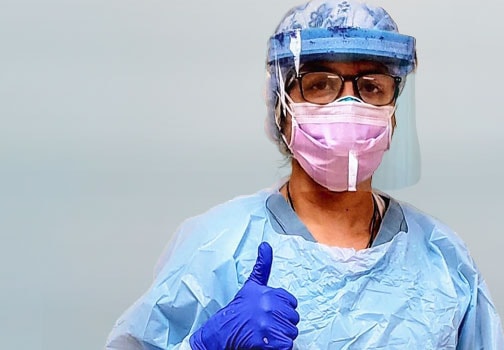 Front line care worker in scrubs an protective mask